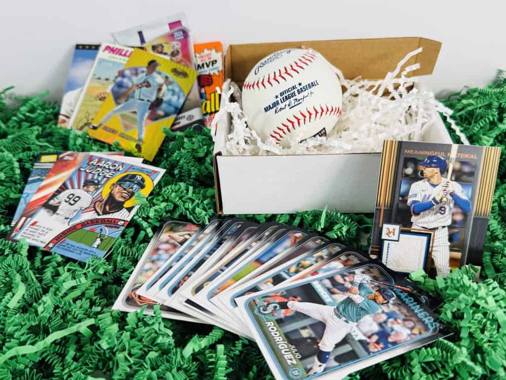 display of baseball cards on a green mat, with memorabilia card and ball